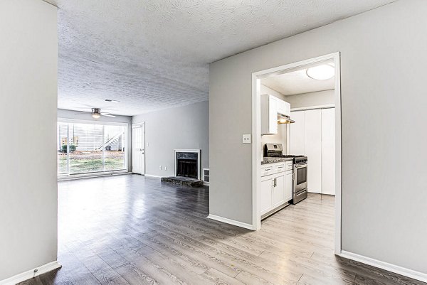 Dining room with elegant lighting and wooden dining set in Hairston Woods Apartments, luxury property by Greystar