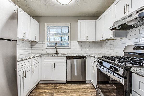 Modern kitchen with stainless steel appliances in Hairston Woods Apartments