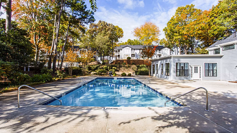Sparkling blue pool at Hairston Woods Apartments with lounge chairs, perfect for relaxation and leisure