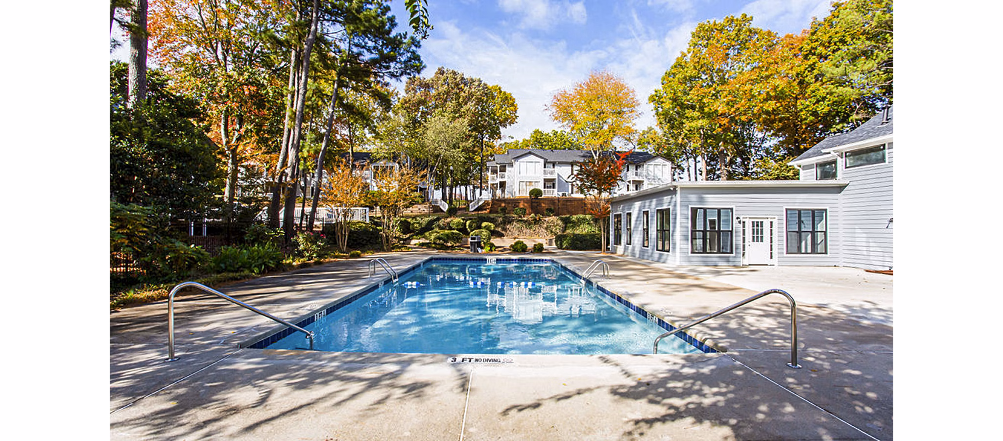 Sparkling blue pool at Hairston Woods Apartments with lounge chairs, perfect for relaxation and leisure