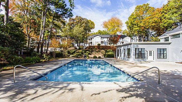 Sparkling blue pool at Hairston Woods Apartments with lounge chairs, perfect for relaxation and leisure