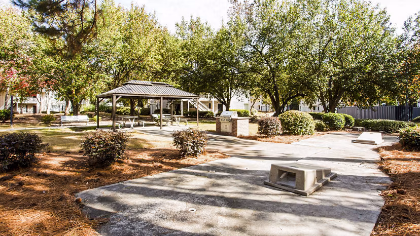 Outdoor grill area with seating at Hairston Woods Apartments, ideal for social gatherings and relaxation