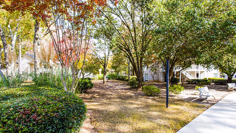 Tranquil courtyard with seating and lush greenery at Hairston Woods Apartments, providing a peaceful outdoor space for residents