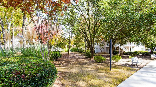 Tranquil courtyard with seating and lush greenery at Hairston Woods Apartments, providing a peaceful outdoor space for residents