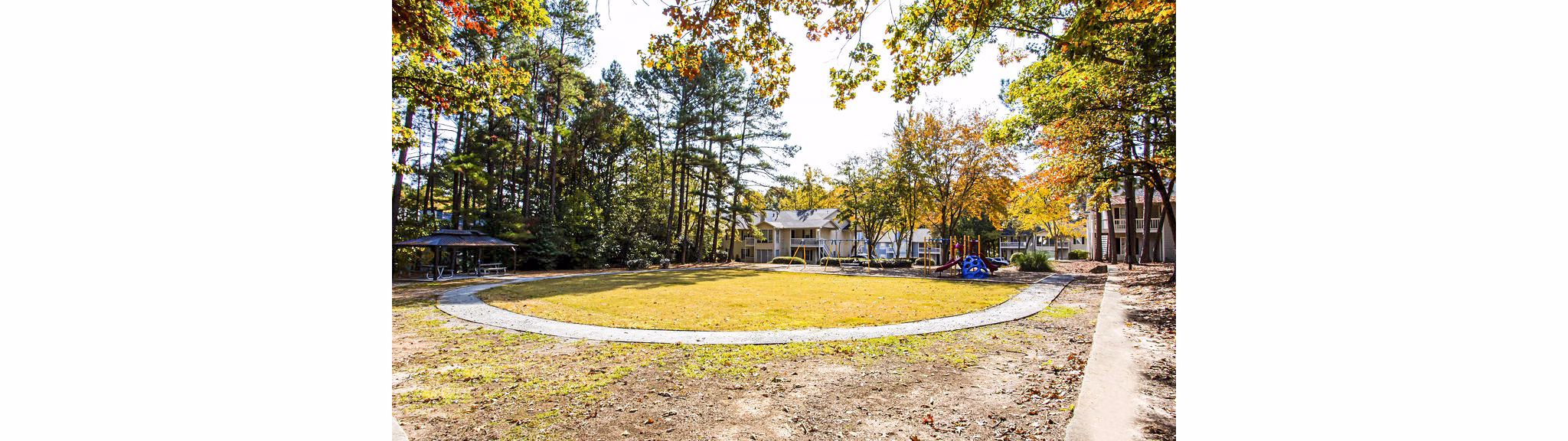 Playground with modern equipment at Hairston Woods Apartments, perfect for family fun and outdoor activity enjoyment