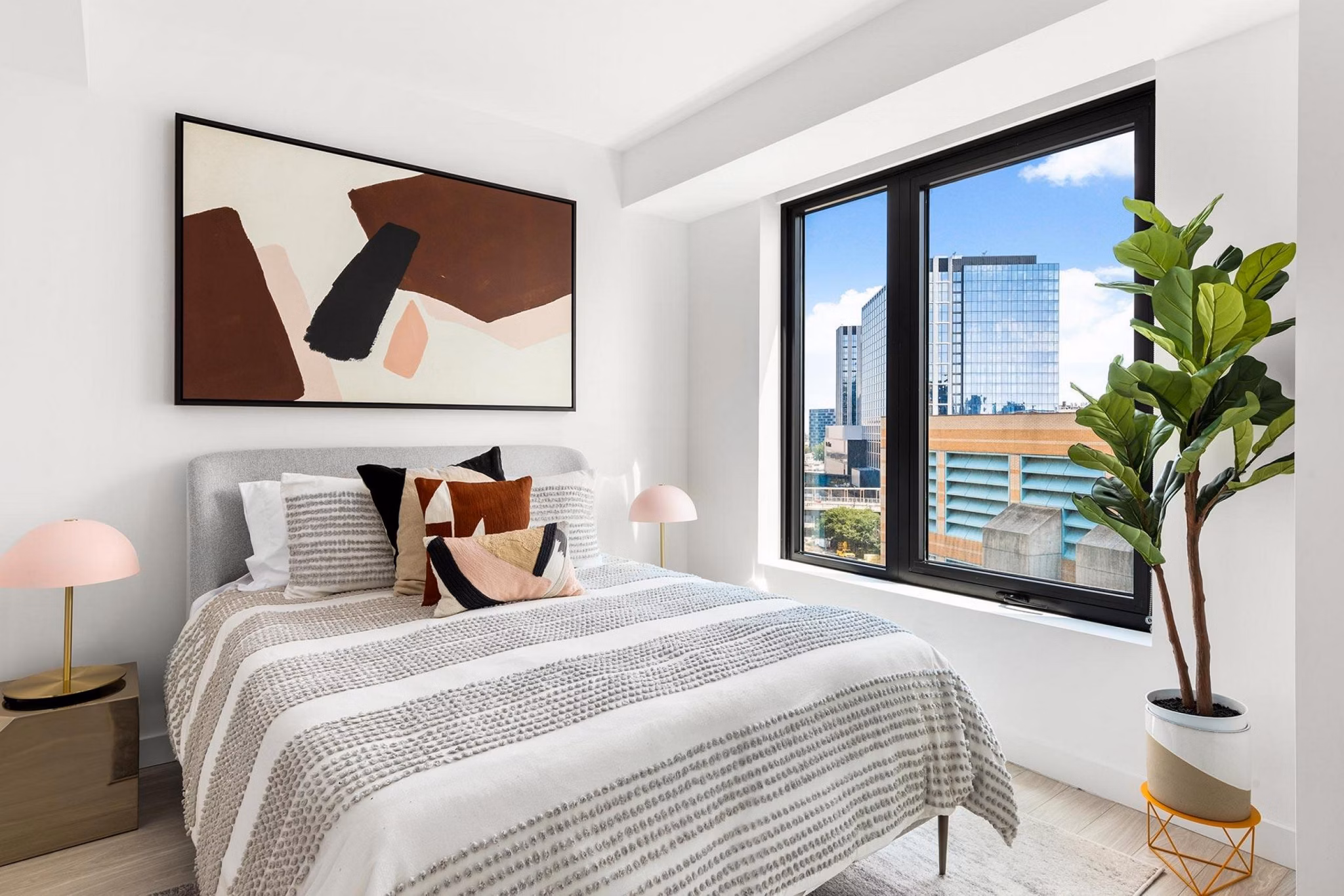 Spacious bedroom with modern decor at The Metlo Apartments featuring elegant bedding and ample natural light