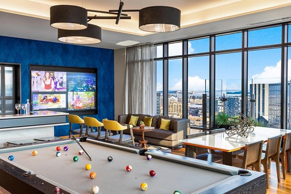 Exciting game room with billiards and arcade games at The Metlo Apartments, offering fun and entertainment in a luxury setting