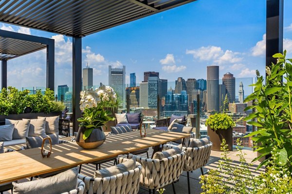 Scenic rooftop deck with seating and city views at The Metlo Apartments