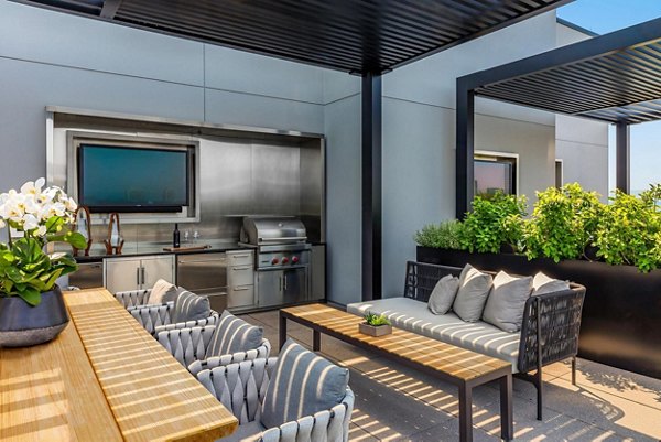 Outdoor grill area with modern seating at The Metlo Apartments, an ideal spot for social gatherings and dining outdoor