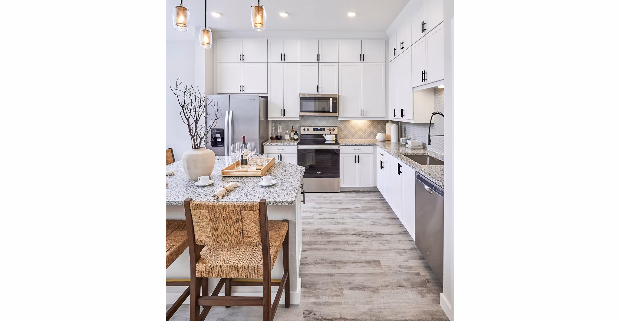 Dining room and kitchen featuring modern appliances at Asbury Apartments