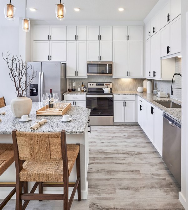 Dining room and kitchen featuring modern appliances at Asbury Apartments