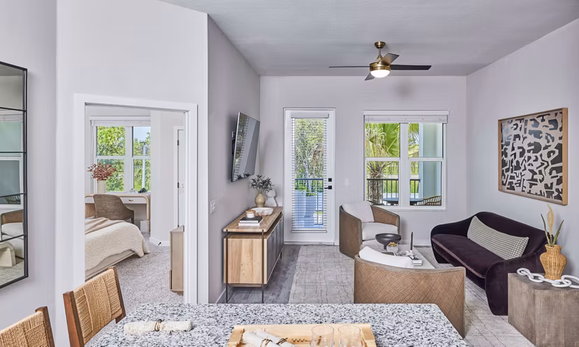 Spacious living room with modern decor and large windows in Asbury Apartments by Greystar