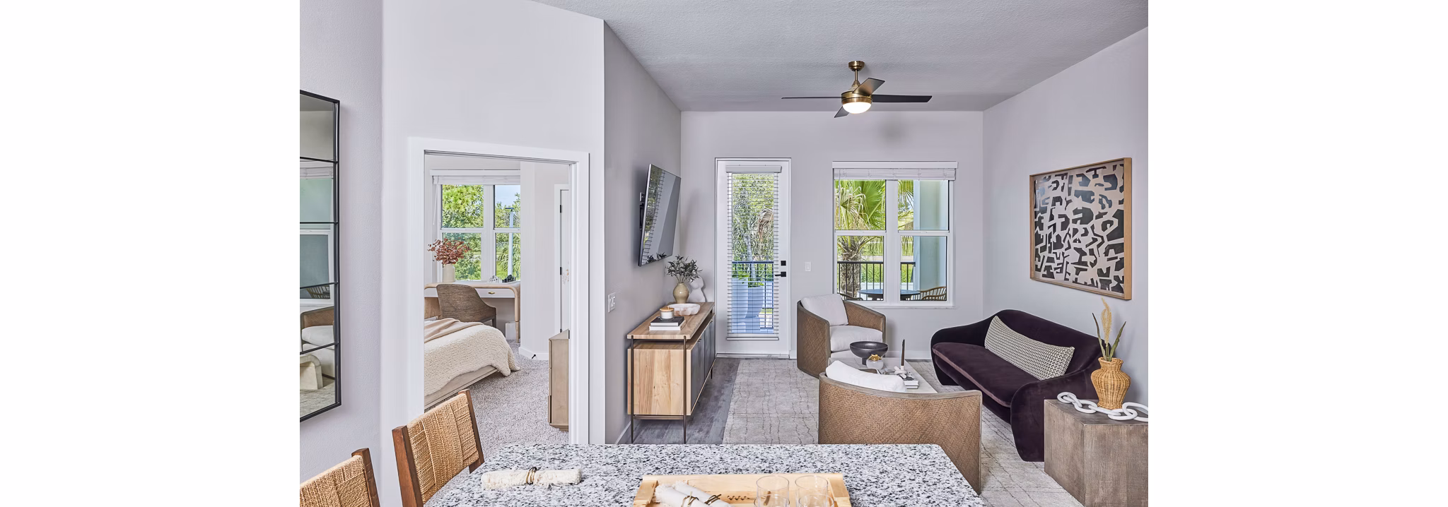Spacious living room with modern decor and large windows in Asbury Apartments by Greystar