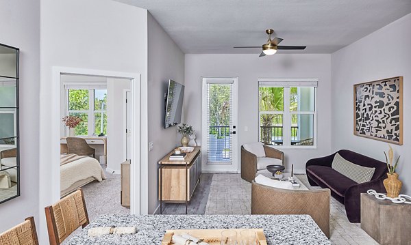 Spacious living room with modern decor and large windows in Asbury Apartments by Greystar