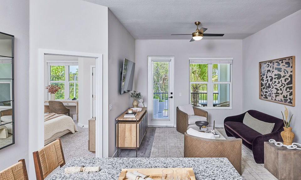 Spacious living room with modern decor and large windows in Asbury Apartments by Greystar