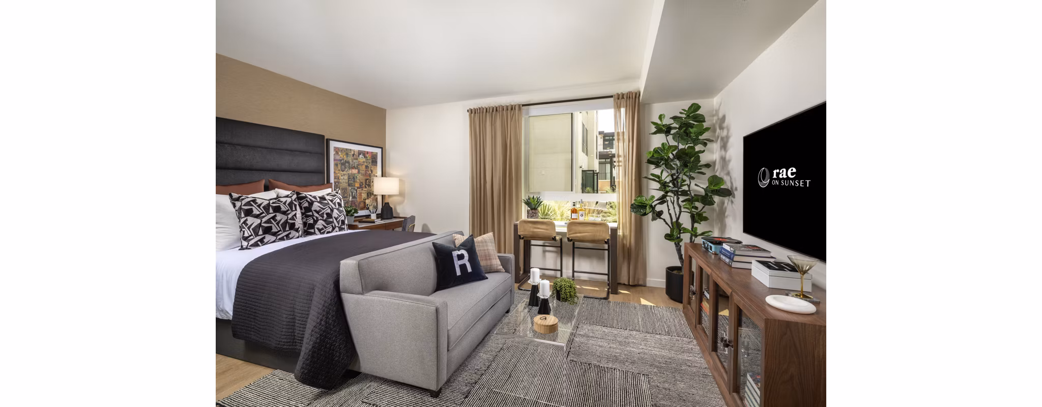Modern bedroom with elegant decor and ample natural light at Rae on Sunset Apartments