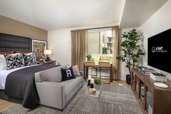 Modern bedroom with elegant decor and ample natural light at Rae on Sunset Apartments