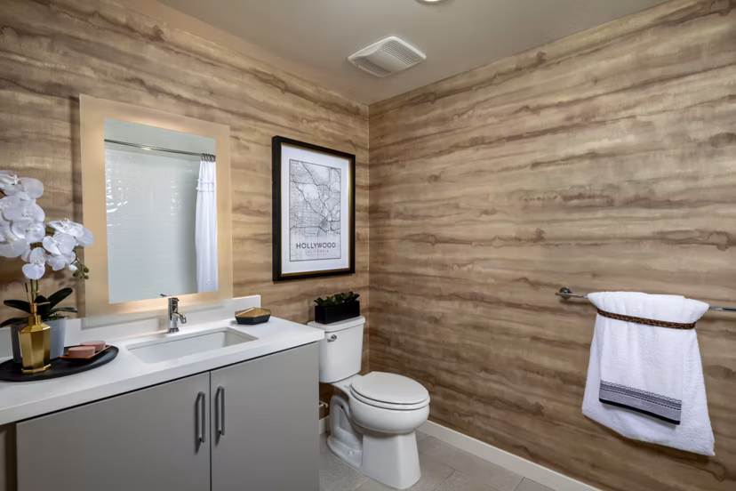 Bathroom with elegant marble countertops and shower at Rae on Sunset Apartments