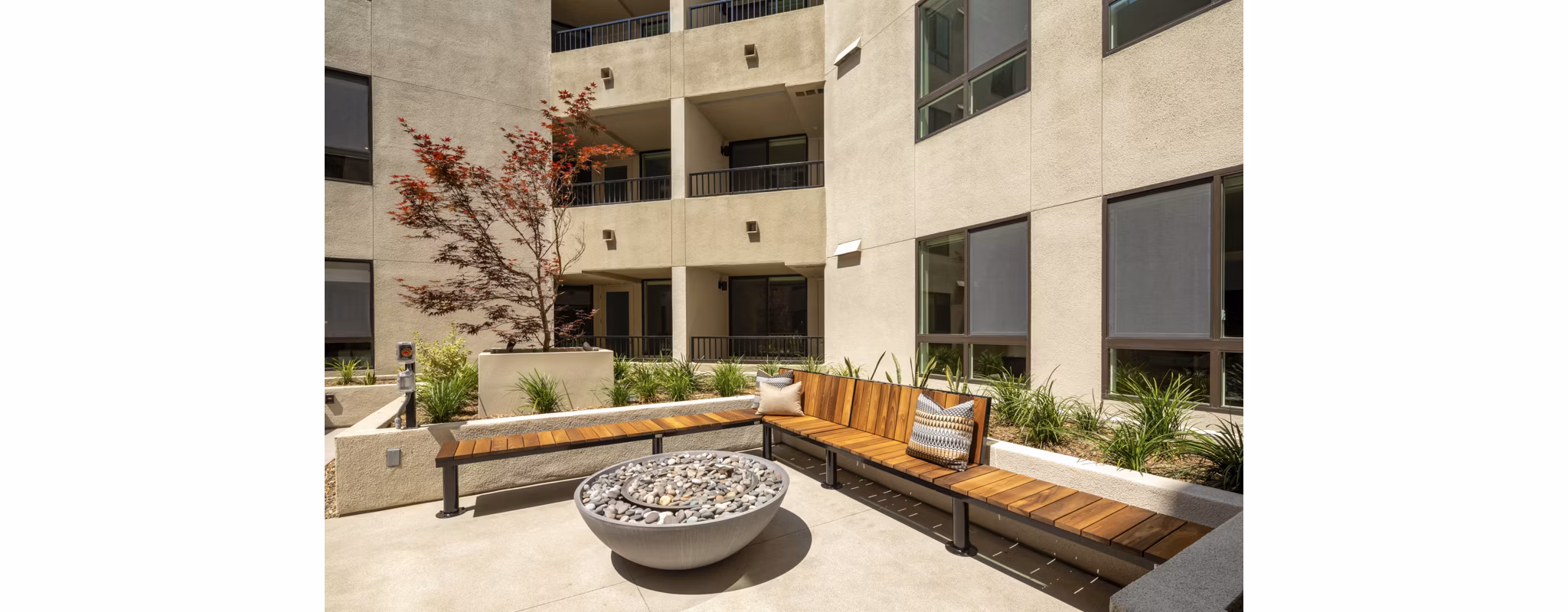 Cozy outdoor fire pit at Rae on Sunset Apartments, ideal for evening gatherings