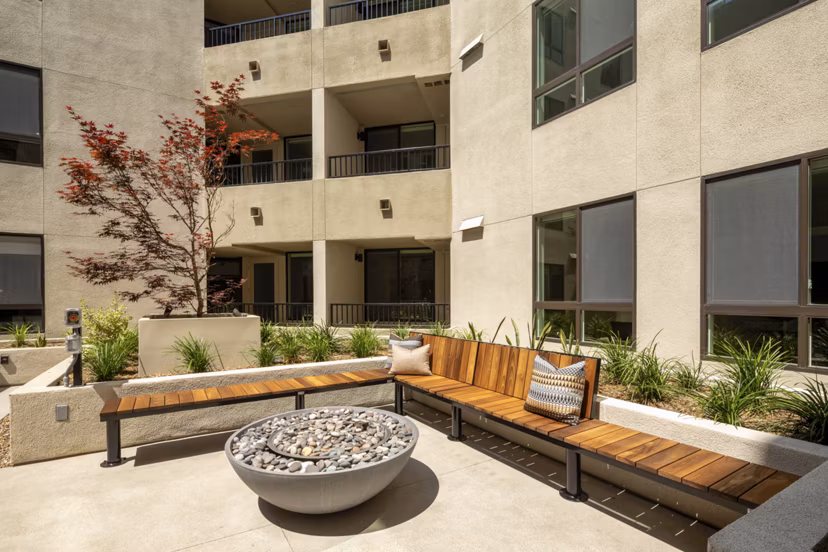 Cozy outdoor fire pit at Rae on Sunset Apartments, ideal for evening gatherings