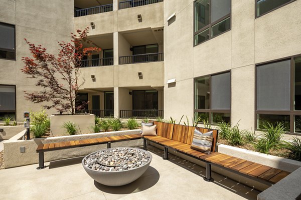 Cozy outdoor fire pit at Rae on Sunset Apartments, ideal for evening gatherings