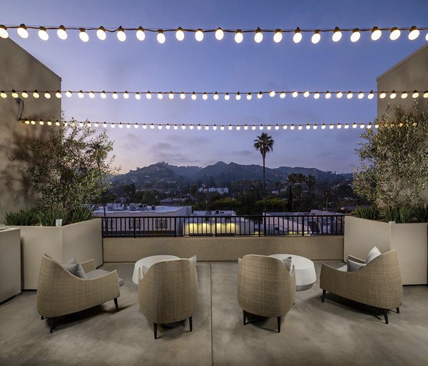 Relaxing rooftop deck with skyline views at Rae on Sunset Apartments, ideal for entertainment and leisure in a luxury setting