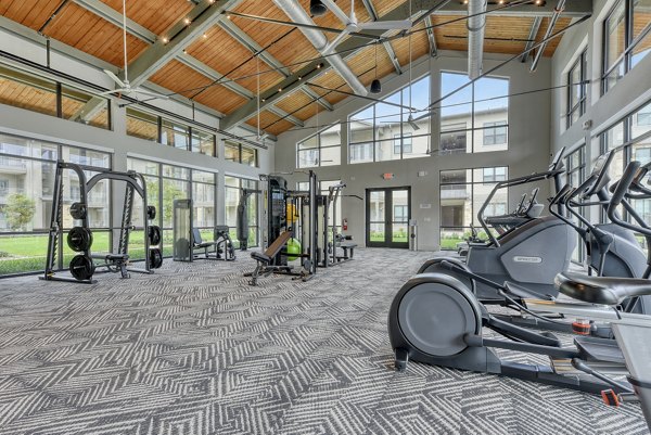 Fitness center with modern equipment at Tacara Gruene Apartments, offering a spacious area for workouts and exercise for residents