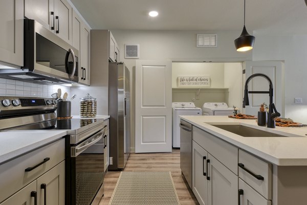 Modern kitchen with island and stainless steel appliances in Tacara Gruene Apartments, luxury living in a prime location for contemporary lifestyles