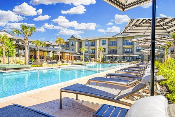 Resort-style pool with lush landscaping at Tacara Gruene Apartments, perfect for relaxation and leisure activities