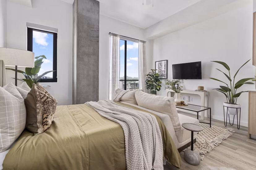 Cozy bedroom with modern decor and large windows at Moontower PHX Apartments