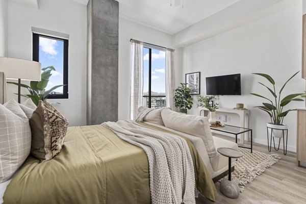 Cozy bedroom with modern decor and large windows at Moontower PHX Apartments