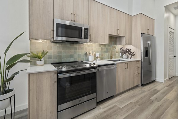 Modern kitchen featuring stainless steel appliances and granite countertops in Moontower PHX Apartments