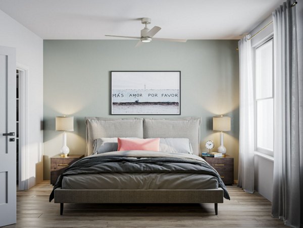 Cozy bedroom featuring modern decor and large windows in The Whitby luxury apartments