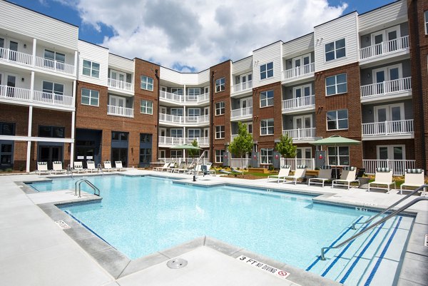 The Whitby: Elegant pool area surrounded by lush gardens in luxury apartments