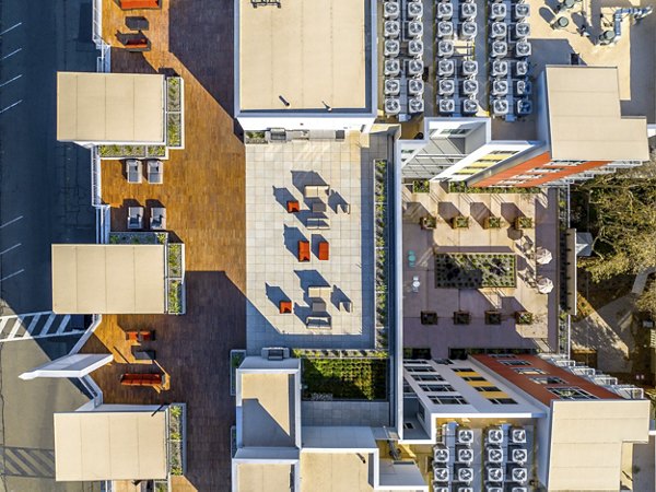 Swimming pool area with red Adirondack chairs and a modern apartment building in luxury apartments