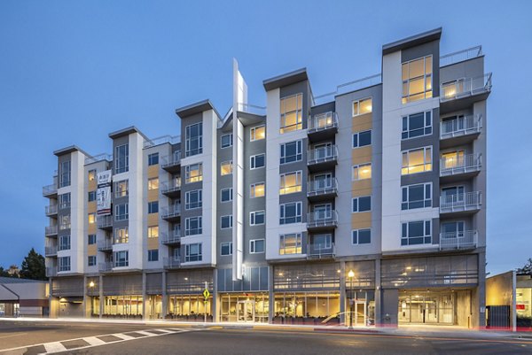 Modern multi-story luxury apartments with balconies and large windows in a vibrant urban setting