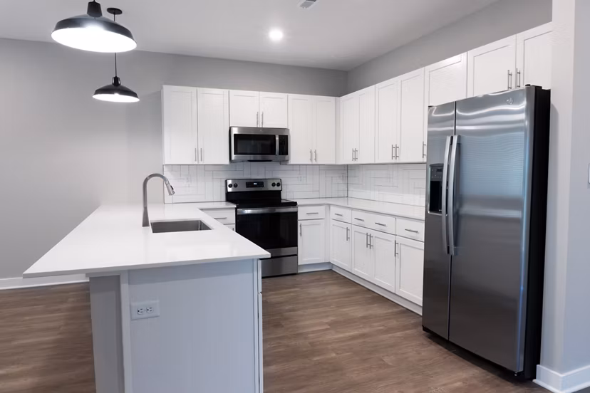 Modern kitchen with stainless steel appliances and granite countertops in Vestara 72 Apartments, luxury living by Greystar