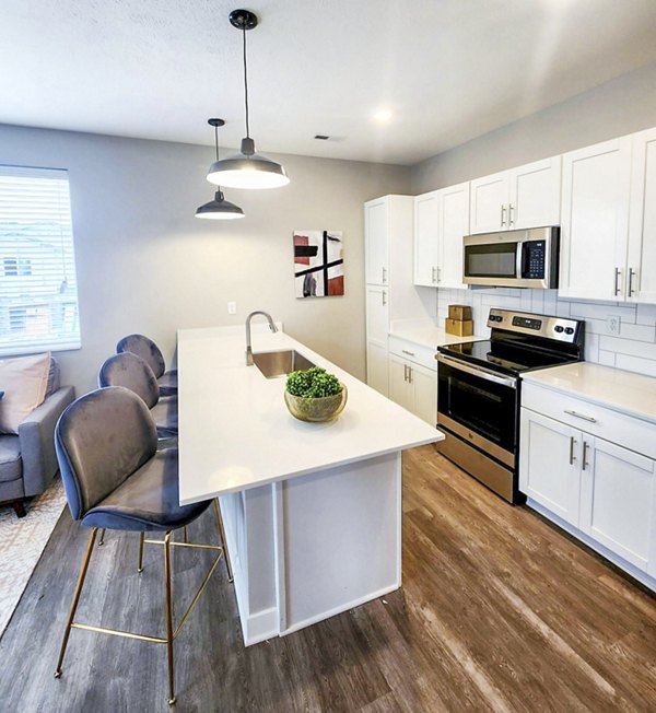 Modern kitchen with stainless steel appliances and granite countertops in Vestara 72 Apartments, luxury living by Greystar