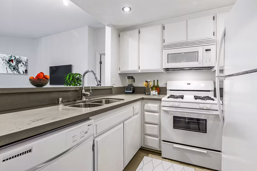 Modern kitchen with sleek appliances and granite countertops at Cahuenga Heights Apartments