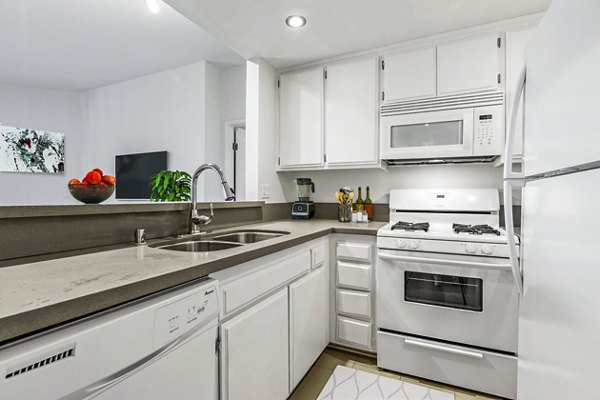 Modern kitchen with sleek appliances and granite countertops at Cahuenga Heights Apartments