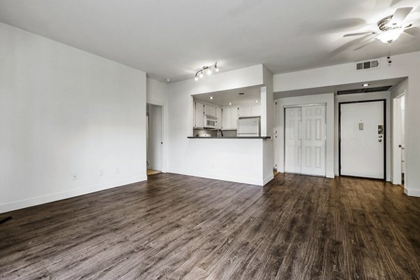 Living room with modern furnishings and large windows at Cahuenga Heights Apartments in Los Angeles