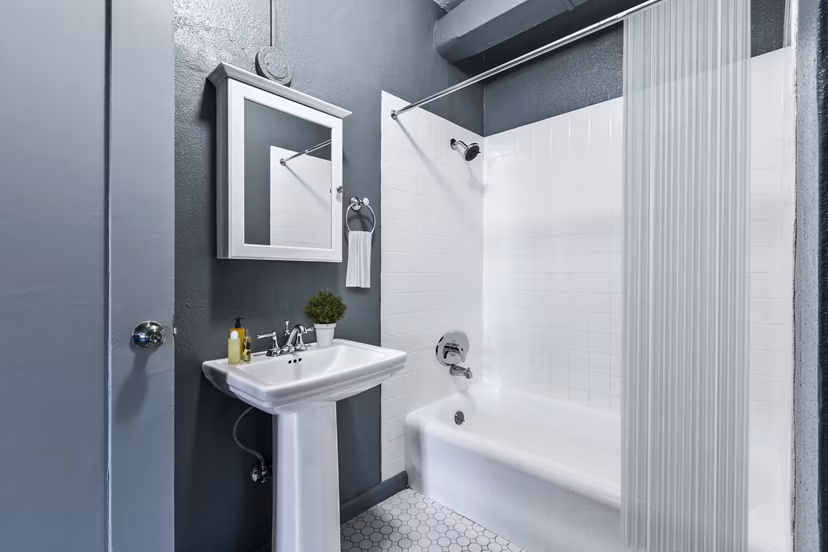 Modern bathroom featuring marble countertops and glass shower at Del Mor Apartments, a luxury community by Greystar