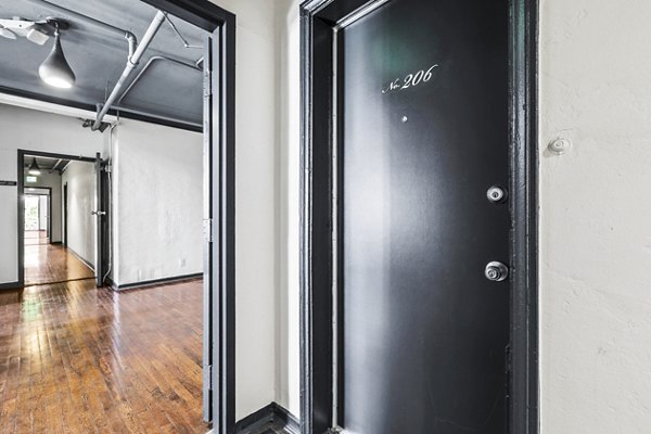 Hallway featuring modern lighting and wood flooring at Del Mor Apartments