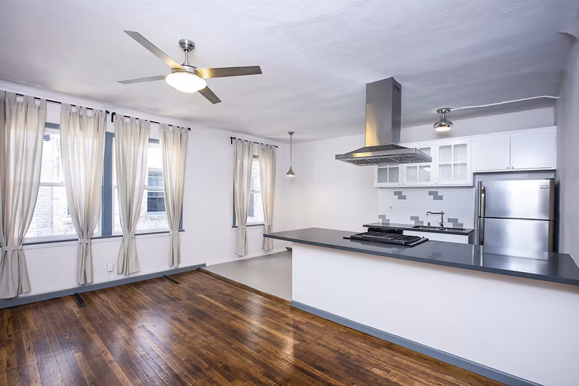 Dining room with elegant lighting and wooden table at Del Mor Apartments