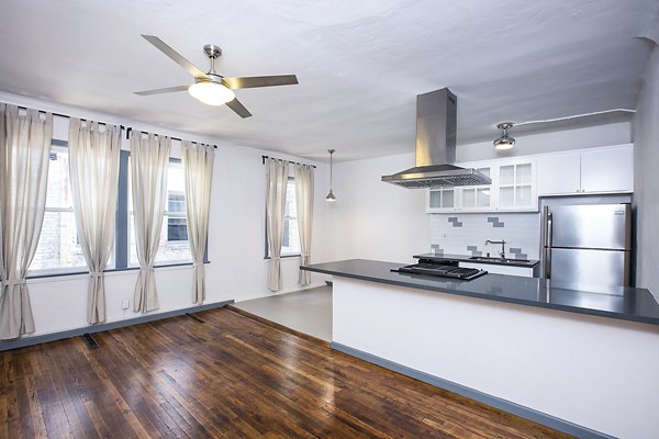 Dining room with elegant lighting and wooden table at Del Mor Apartments