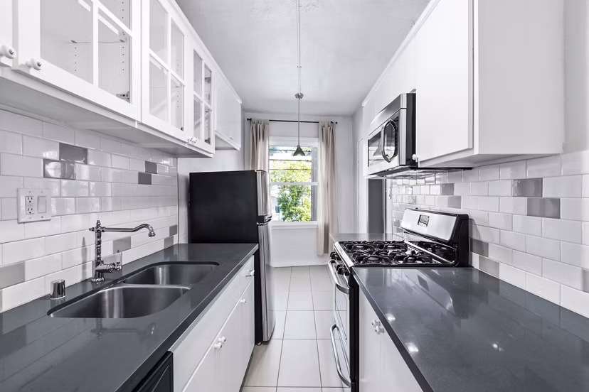 Modern kitchen with stainless steel appliances at Del Mor Apartments, a Greystar luxury apartment community
