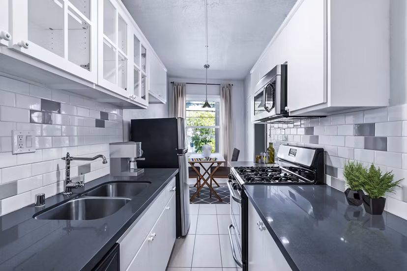 Modern kitchen with sleek countertops and stainless steel appliances at Del Mor Apartments