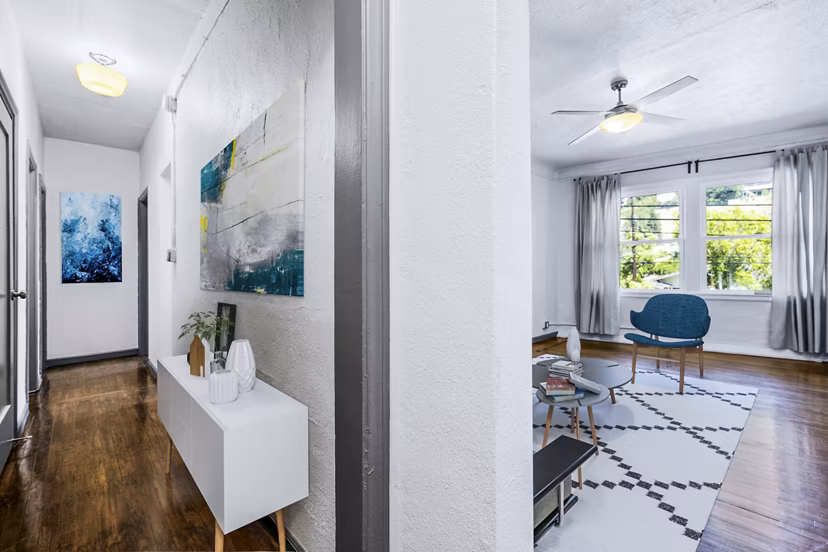 Hallway leading to a spacious living room with modern furnishings at Del Mor Apartments