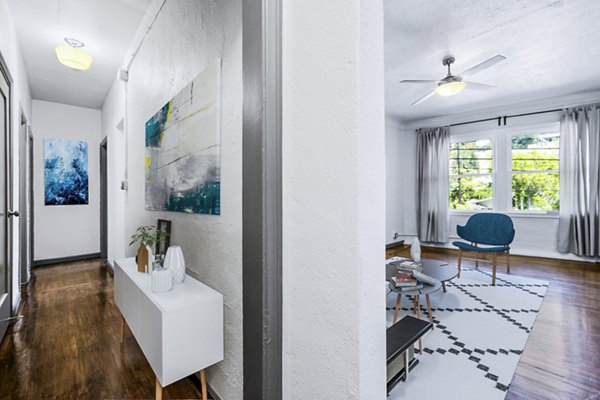 Hallway leading to a spacious living room with modern furnishings at Del Mor Apartments