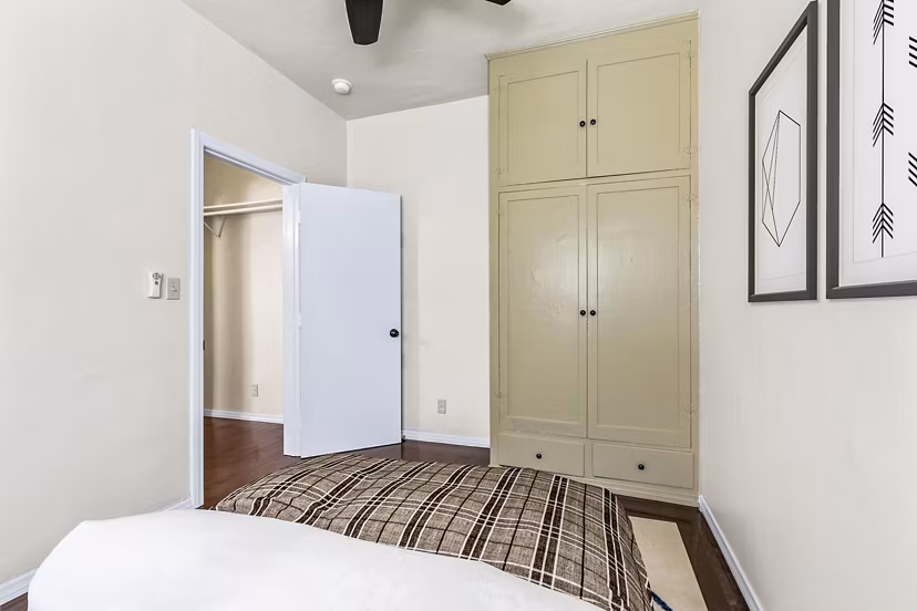 Cozy bedroom featuring modern dÃ©cor and large windows at Delta Apartments